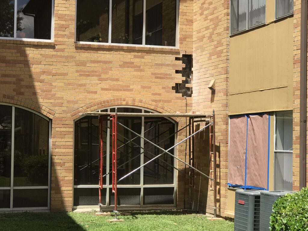 Damaged yellow brick facade of a building